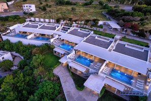 Een modern resort met meerdere zwembaden, buitenzitplekken en een verzorgd landschap.