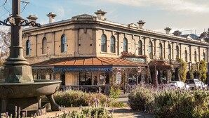 Un bâtiment historique abritant un restaurant appelé « Frangos » et une enseigne indiquant « PIZZERIA » au rez-de-chaussée.