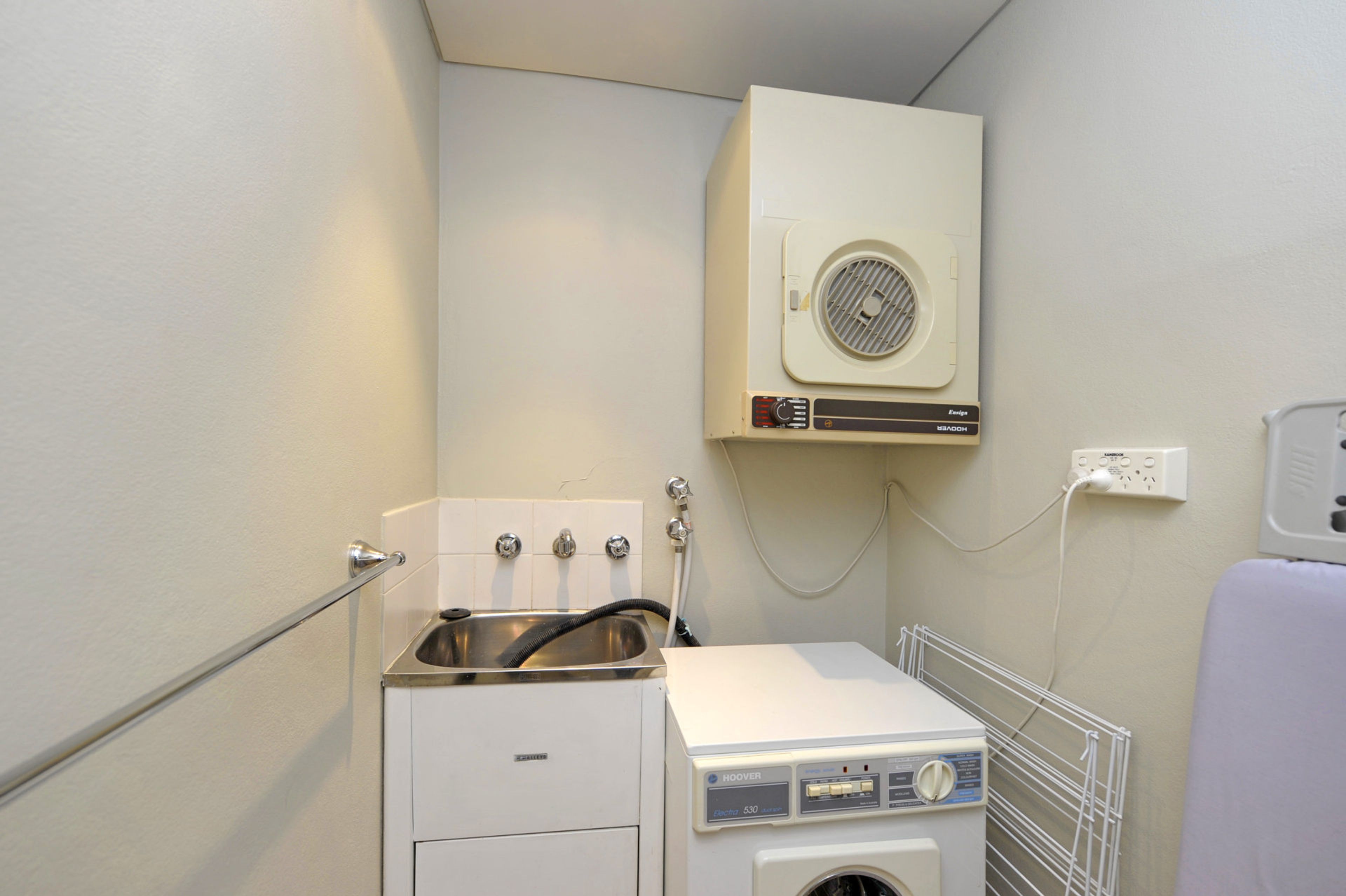 A compact laundry room with a washing machine, a dryer, and a built-in dryer vent.