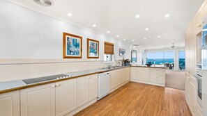 Enjoy meals in this kitchen with ocean views, featuring a dining area and modern cabinetry.