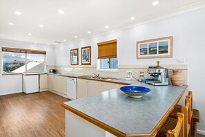 A modern kitchen with a built-in dishwasher, a coffee machine, and a large window with a view. - Birubi Beach getaway at Anna Bay (Anna Bay)