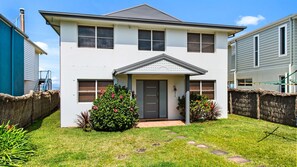 Stunning two-story home with a central entrance, double doors, and a small porch area.