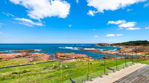 Enjoy breathtaking views of the ocean from this expansive deck overlooking the rocky coastline.