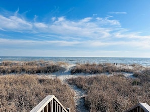 A beach path leading to a wooden structure with a clear view of the ocean. - Experience beachfront bliss at Sea It All in Holden Beach, NC, perfect for 6 guests. (Holden Beach)