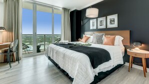 Quarto moderno com uma cama grande, uma escrivaninha e vista para a cidade.