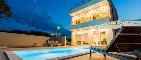 Una piscina al aire libre, tumbonas