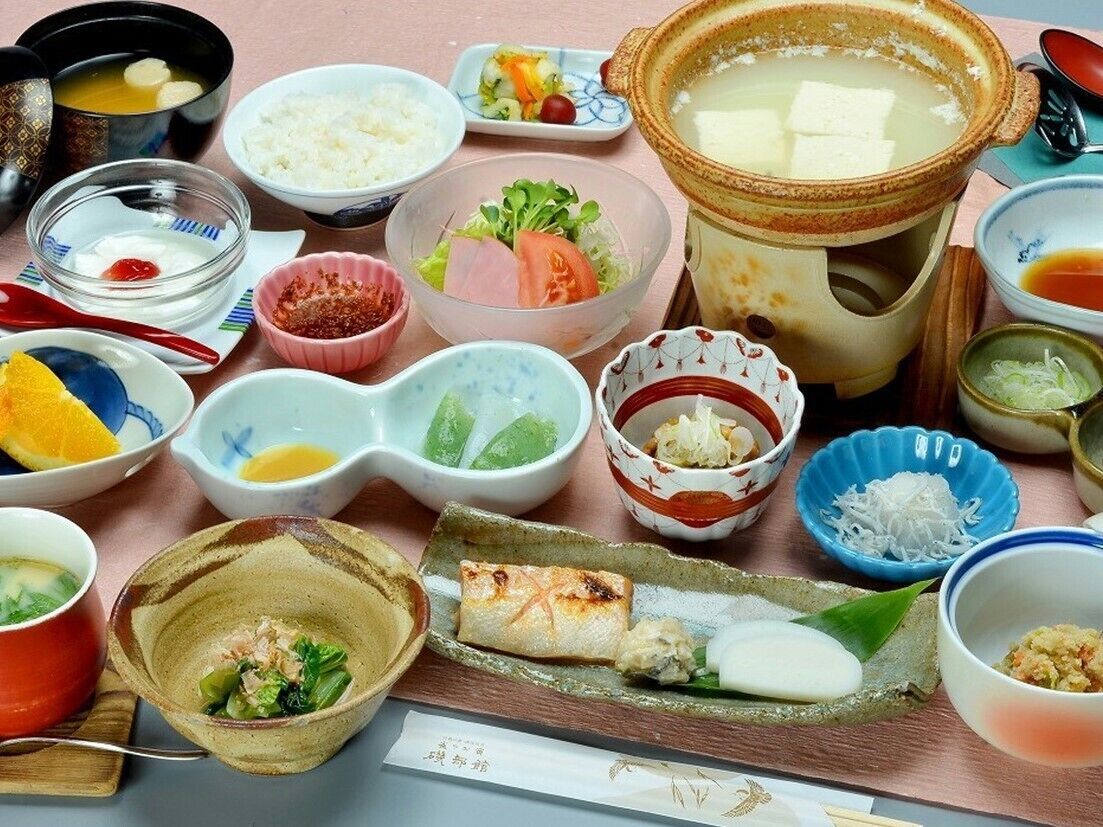 A variety of Japanese dishes including sushi, rice, and soup, arranged on a table.