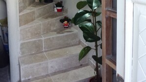 A staircase with a wooden wall, potted plants, and a door frame. - Wonderful house at the heart of Provence 1km to beach with terrace and parking (Fos-Sur-Mer)