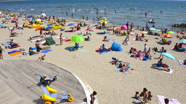 A crowded beach with people sunbathing and swimming, colorful umbrellas, and a wooden boardwalk. - Wonderful house at the heart of Provence 1km to beach with terrace and parking (Fos-Sur-Mer)