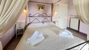 Ein Schlafzimmer mit einem Bett, einem Nachttisch, einem Heizkörper und einer Tür.