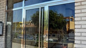 Ein Gebäude mit großen Glasfenstern, die eine Straßenszene spiegeln.