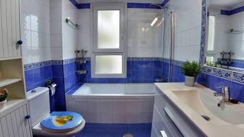 Een bad/douchecombinatie, een haardroger, een bidet, handdoeken