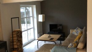 Un salon moderne avec un canapé, une table basse et une cheminée.