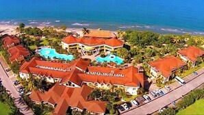 Een resort met meerdere gebouwen, een zwembad en een strand.