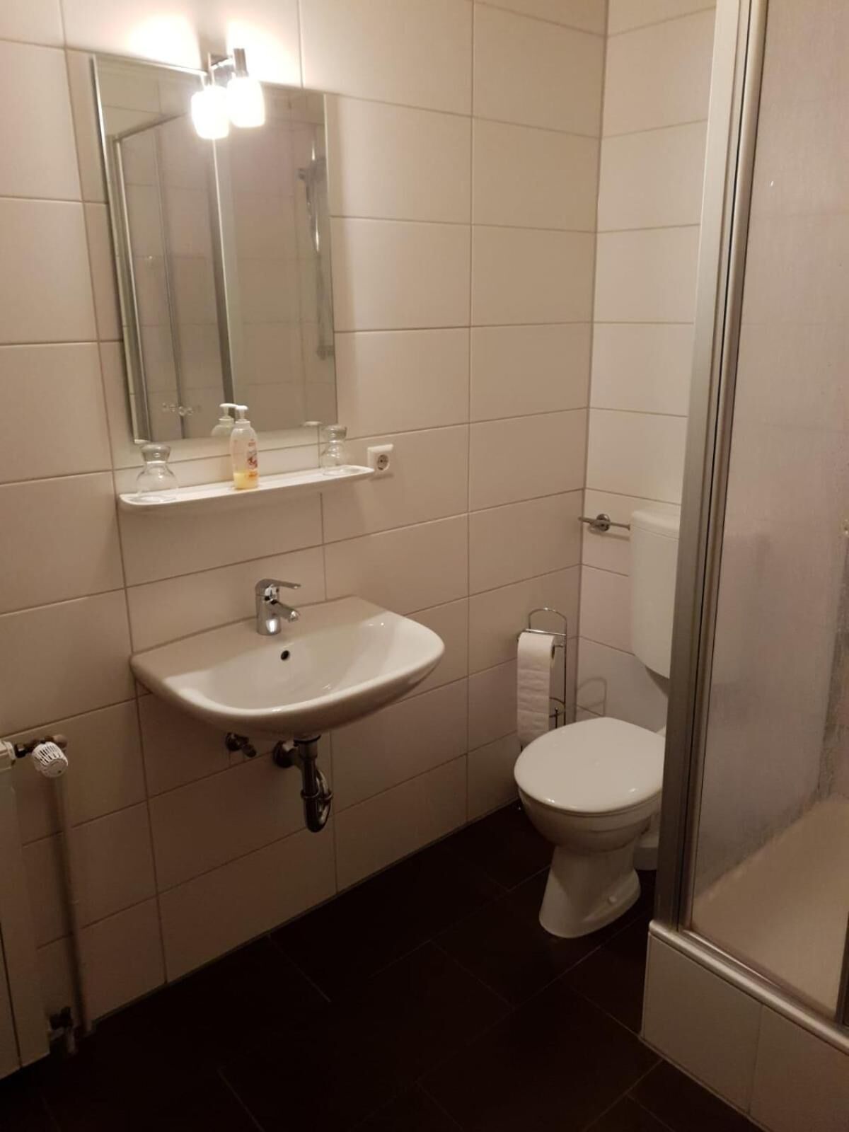 Ein Badezimmer mit Waschbecken, Spiegel und Toilette.