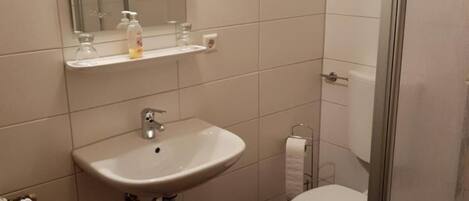 Ein Badezimmer mit Waschbecken, Spiegel und Toilette.