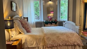 A bedroom with a large bed, two bedside tables, a nightstand, a mirror, and a window with curtains. - Florence Loft Duomo (Firenze)