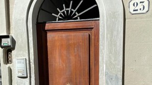 A wooden door with a brass doorknob, a mailbox, and a house number 23. - Florence Loft Duomo (Firenze)