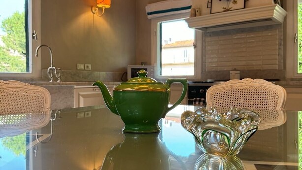 A kitchen with a glass table, a green teapot, and a glass pitcher. - Florence Loft Duomo (Firenze)
