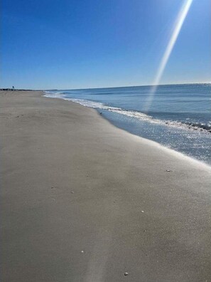 A beach with a clear sky and calm sea. - Toadally Relaxin': Cozy 2BR Duplex near the beach in Holden Beach, NC. (Holden Beach)
