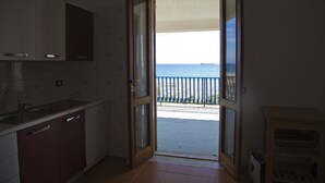 A kitchen with a view of the sea through an open door. - Ferruzzano portion of villa with stunning views and direct access to the sea (ferruzzano)