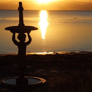 Silueta de una fuente contra un atardecer.