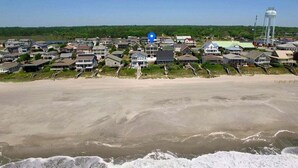 Une zone résidentielle côtière comprenant des maisons, une plage et un château d’eau.