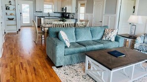 Un salon spacieux comprenant un canapé, une table basse et un coin repas avec des chaises et une table.