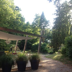 A garden pathway with a wooden pergola and potted plants. - 5-hectare family estate with swimming pool near Bourges (Berry-Bouy)