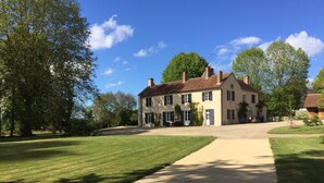 A large, two-story house with a paved driveway leading to the front door. - 5-hectare family estate with swimming pool near Bourges (Berry-Bouy)