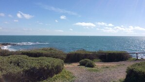 A coastal view with a clear sky, a sandy beach, and a wooden fence. - Bright seafront house with superb sea view, 2 free parking spaces. (Cap d'Agde)