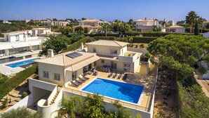 Eine moderne Villa mit Schwimmbad, mehreren Lounges und einem gepflegten Garten.