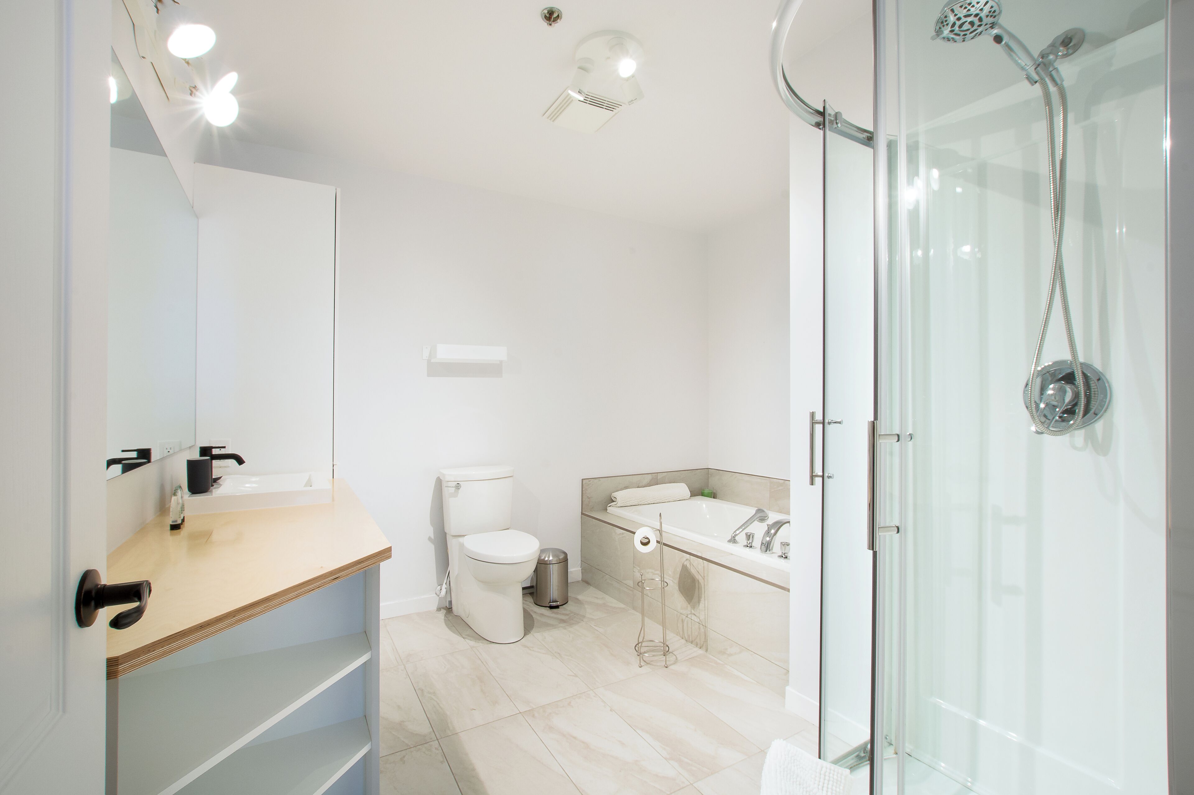 A modern bathroom with a toilet, sink, and shower.