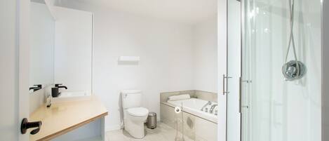 A modern bathroom with a toilet, sink, and shower.