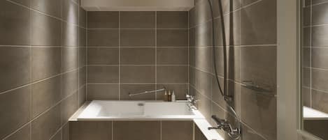 Un baño moderno con una bañera grande, ducha y barandilla.