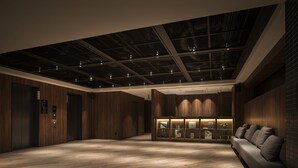 Un hall d’entrée moderne avec un plancher en bois, un canapé et une vitrine.