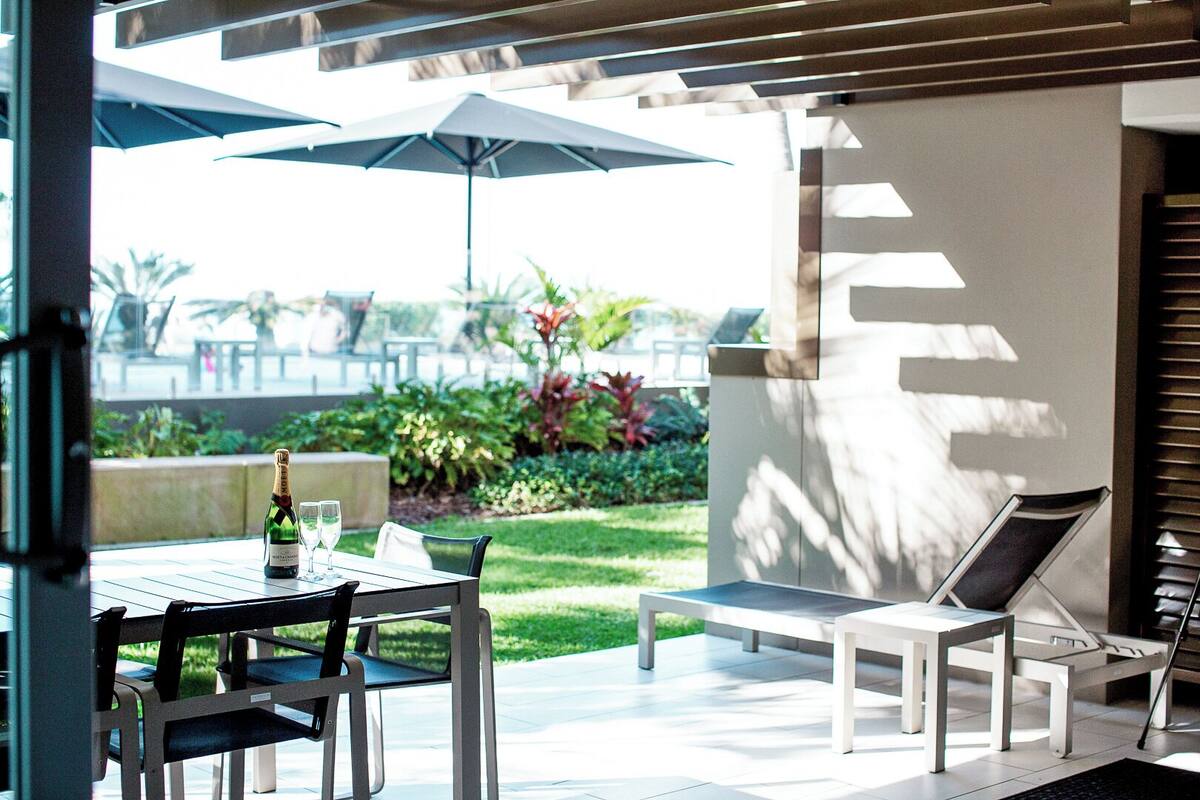 Een terras met een tafel, stoelen en parasols.