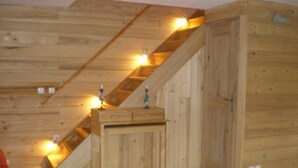 Una escalera de madera con un escritorio de madera y una puerta.