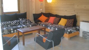 Una habitación con paneles de madera, un sofá, una mesa de centro y una silla.