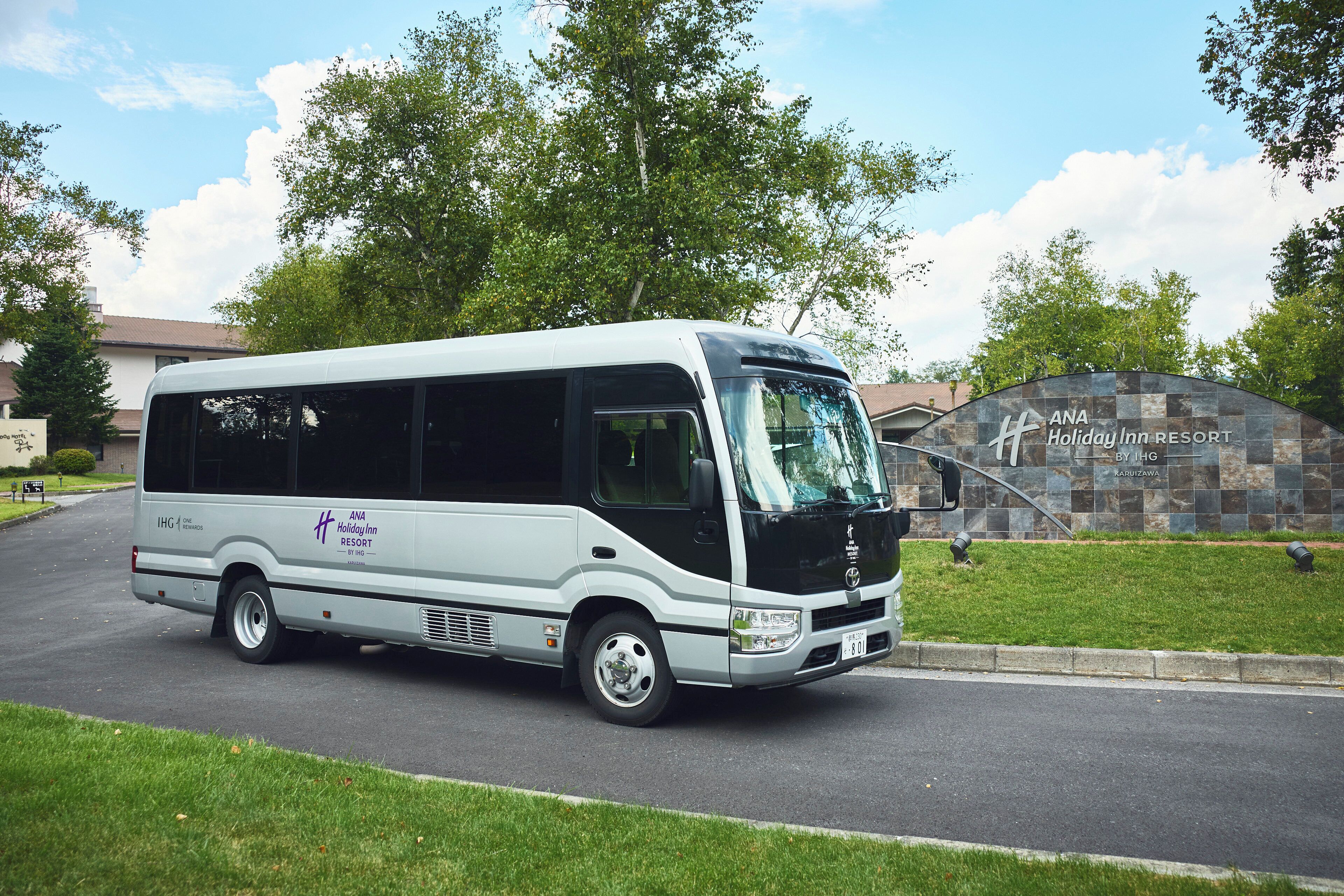 A white bus parked in front of ANA Holiday Inn Resort.