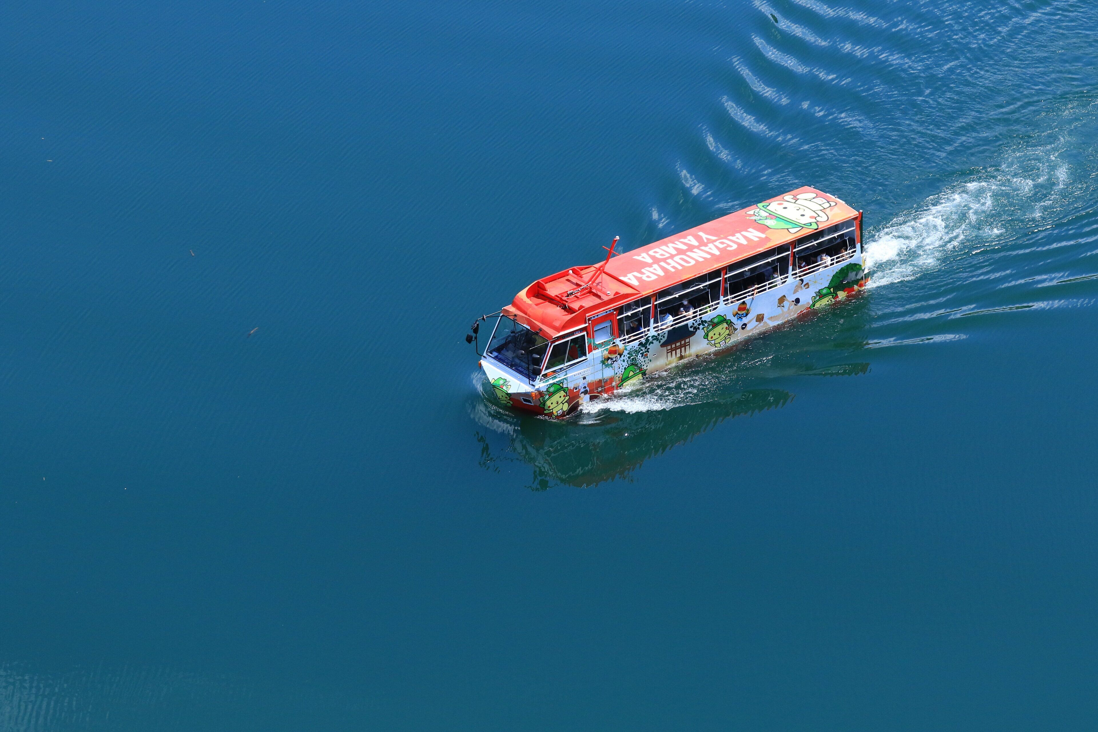 A boat with a colorful design and text on its side, moving through water.