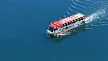 A boat with a colorful design and text on its side, moving through water.