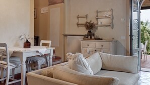 A cozy room with a dining area, a sofa, and a radiator.