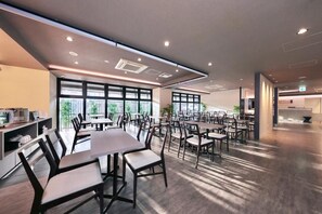 A spacious conference room with multiple tables and chairs, large windows, and a modern ceiling design. - Hotel Japanesque Kyoto Station ZEQUU (Kyoto)