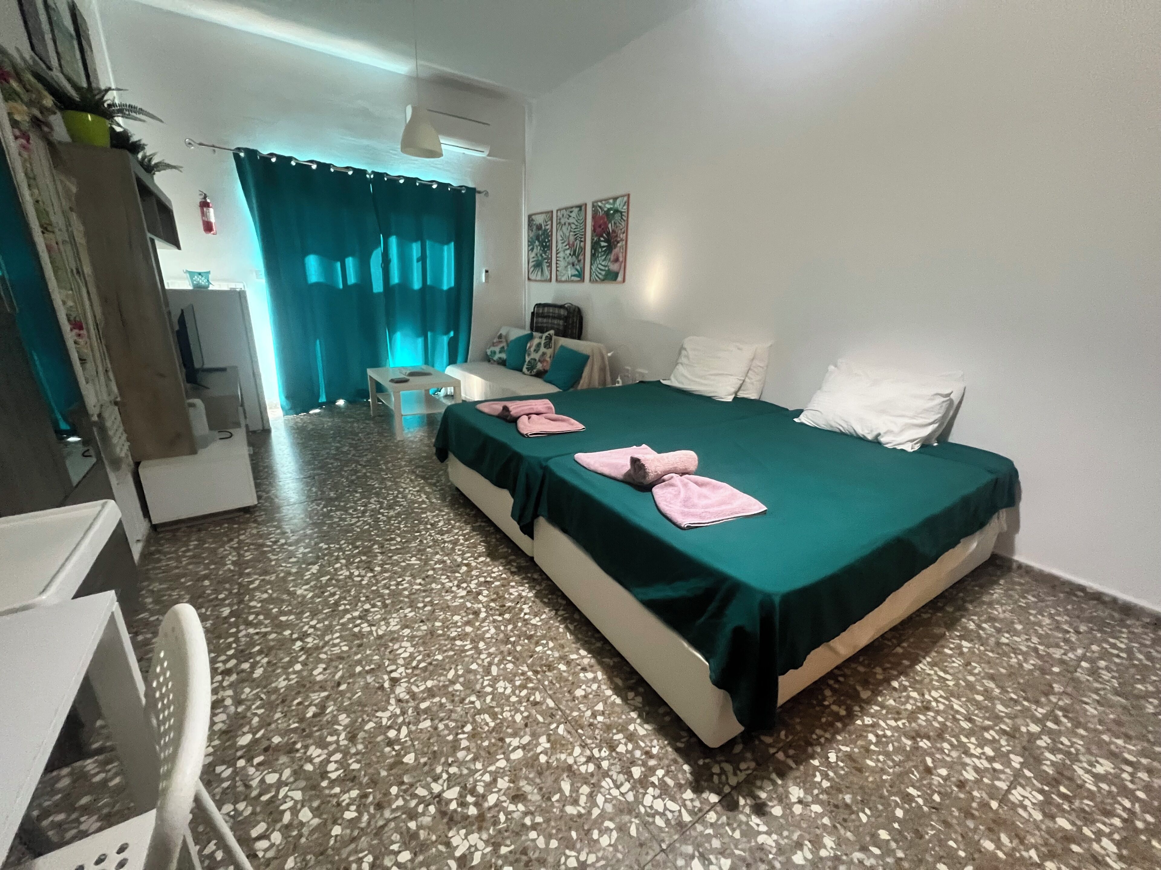 Ein Hotelzimmer mit Bett, Schreibtisch, Stuhl, einem kleinen Tisch und einem durch eine offene Tür einsehbaren Badezimmer.