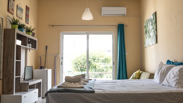 A bedroom with a bed, a desk, a TV, and a window with curtains. - Lucky 2 - Great location, close to the most beautiful beaches of Cyprus! (Paralimni)