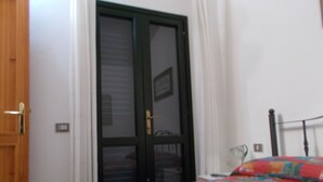 A bedroom with a bed, a wooden door, and a wardrobe. - Villa with sea view .. (Geremeas)