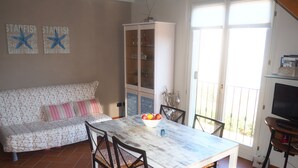 Un comedor con una mesa, sillas, un armario y un sofá.