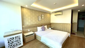 Une chambre moderne avec un grand lit, une tête de lit en bois, des tables de chevet et un panneau décoratif mural.