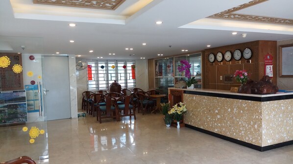 Un hall d’hôtel comprenant un comptoir d’accueil, un espace salon et des éléments décoratifs.